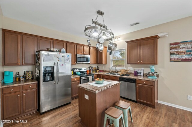 kitchen with visible vents, stainless steel appliances, a sink, and wood finished floors