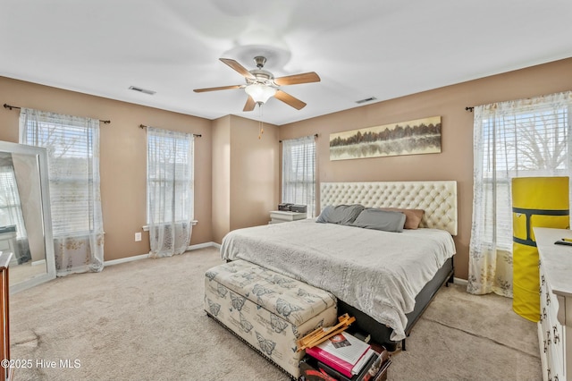 carpeted bedroom featuring visible vents, baseboards, and a ceiling fan