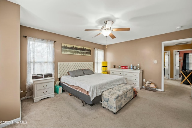 bedroom with light carpet, ceiling fan, visible vents, and baseboards