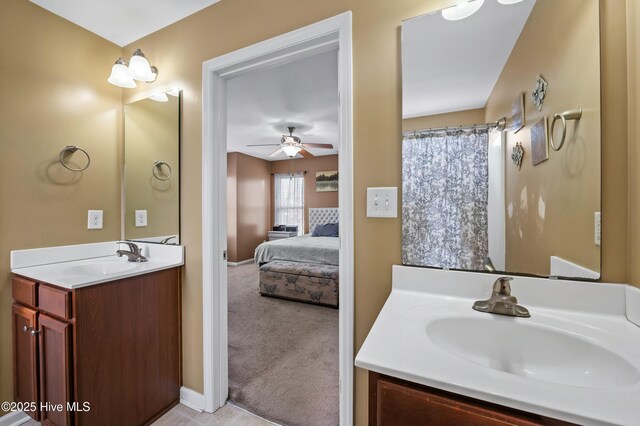 bathroom with ceiling fan, two vanities, a sink, and ensuite bathroom