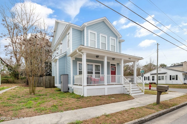 view of front of property featuring covered porch and fence