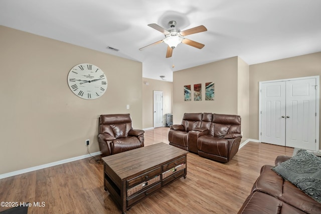 living area featuring light wood-style flooring, visible vents, and baseboards