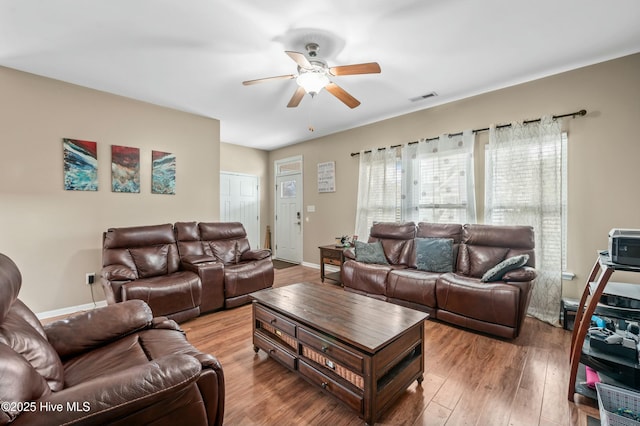 living room with ceiling fan, wood finished floors, visible vents, and baseboards