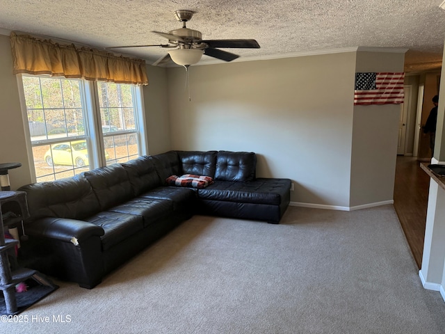 carpeted living area with a textured ceiling, ceiling fan, crown molding, and baseboards