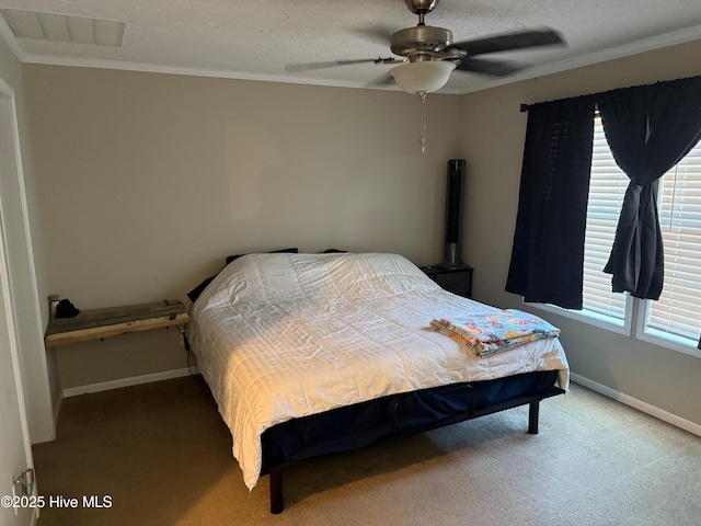 carpeted bedroom featuring a textured ceiling, baseboards, a ceiling fan, and ornamental molding