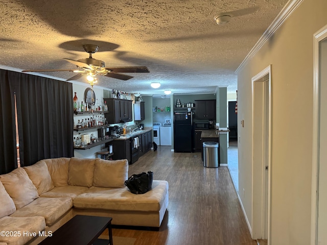 living room with dark wood-style floors, a dry bar, ornamental molding, a textured ceiling, and separate washer and dryer