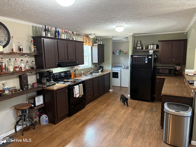 kitchen with light wood-style flooring, open shelves, washer and dryer, black appliances, and crown molding