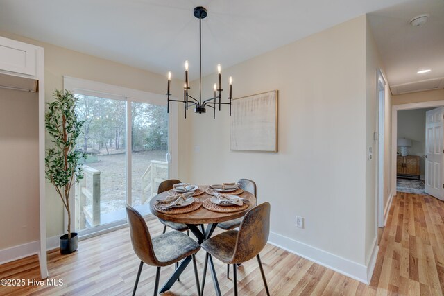 dining area with light wood finished floors, baseboards, and a chandelier