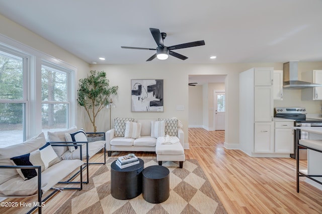 living room with a ceiling fan, recessed lighting, light wood-style flooring, and baseboards