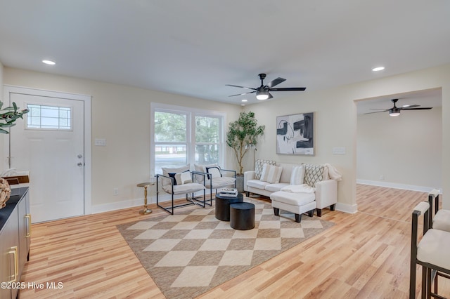 living room featuring ceiling fan, light wood finished floors, recessed lighting, and baseboards