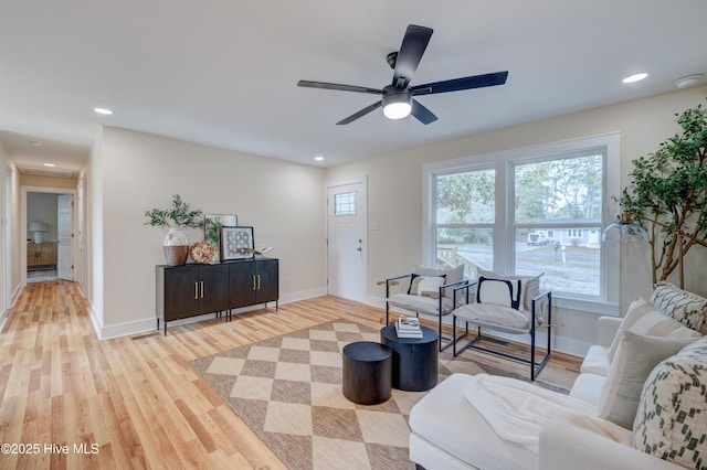 living room with baseboards, ceiling fan, light wood finished floors, and recessed lighting