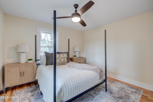 bedroom with ceiling fan, baseboards, and wood finished floors