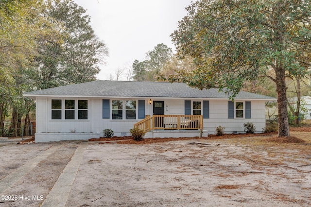 ranch-style house with roof with shingles, a porch, and crawl space