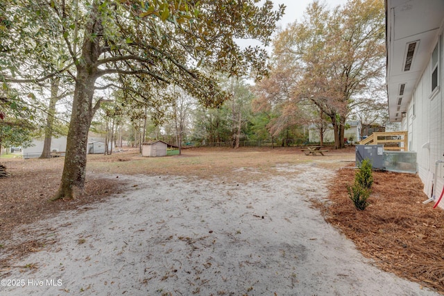 view of yard with an outdoor structure, fence, and a shed