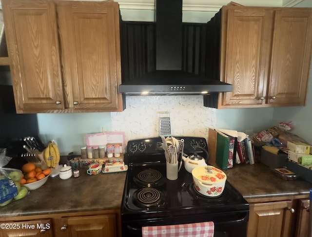 kitchen featuring dark countertops, tasteful backsplash, brown cabinetry, black electric range oven, and wall chimney exhaust hood