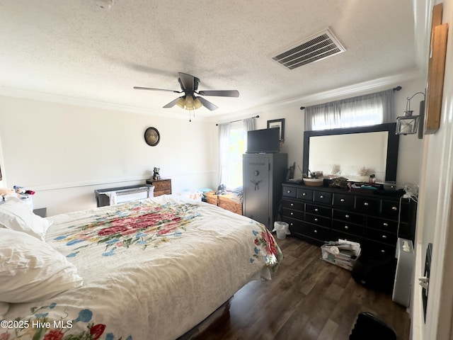 bedroom with visible vents, crown molding, ceiling fan, dark wood finished floors, and a textured ceiling