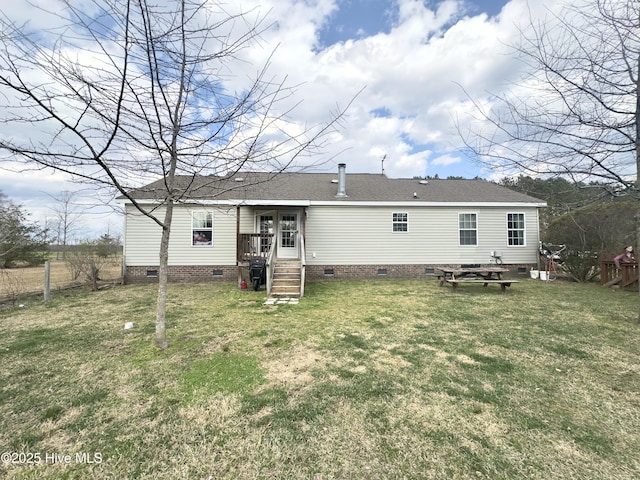 rear view of house featuring fence, a lawn, roof with shingles, and crawl space