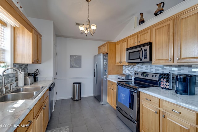 kitchen featuring an inviting chandelier, lofted ceiling, a sink, stainless steel appliances, and backsplash