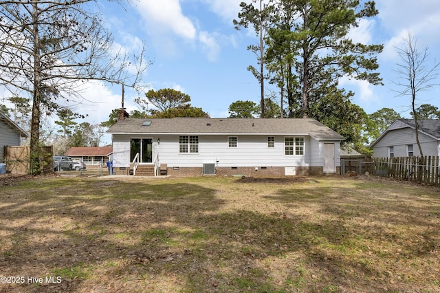 back of house featuring entry steps, a yard, crawl space, and a chimney