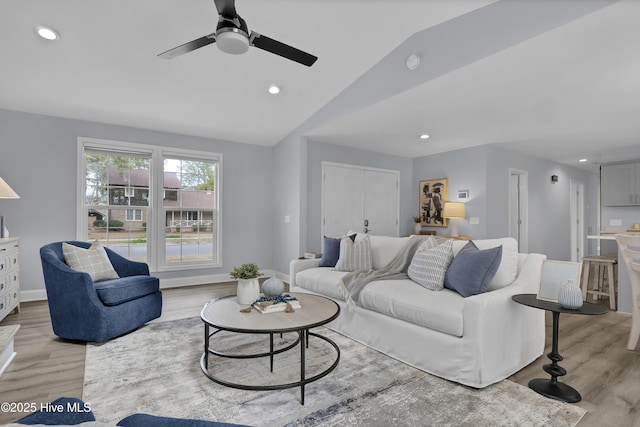 living room with lofted ceiling, light wood finished floors, baseboards, and recessed lighting