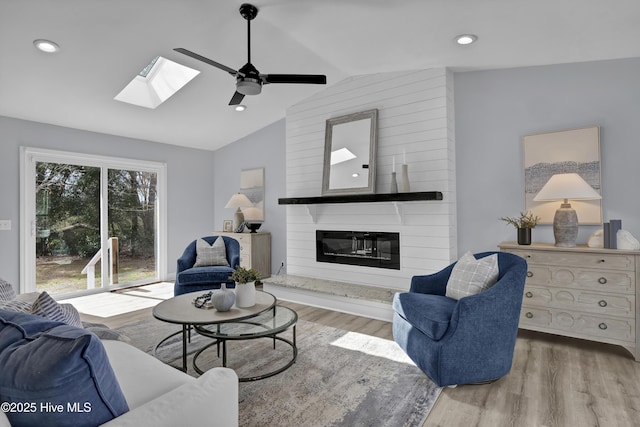 living area featuring ceiling fan, recessed lighting, a premium fireplace, wood finished floors, and vaulted ceiling