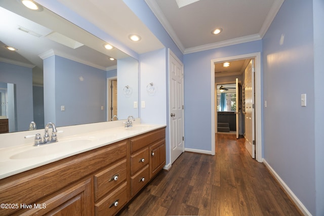 bathroom with ornamental molding, wood finished floors, visible vents, and a sink