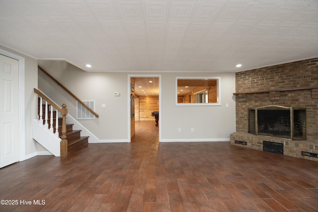 unfurnished living room featuring visible vents, baseboards, stairway, recessed lighting, and wood finished floors