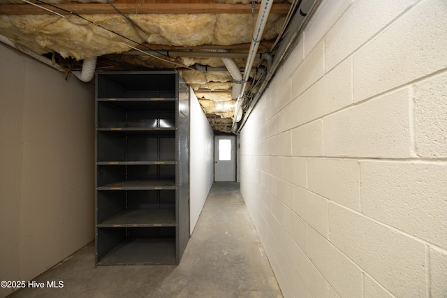 corridor with unfinished concrete floors and concrete block wall