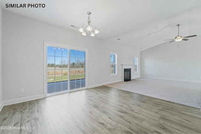 unfurnished living room featuring baseboards, a fireplace with flush hearth, wood finished floors, and ceiling fan with notable chandelier