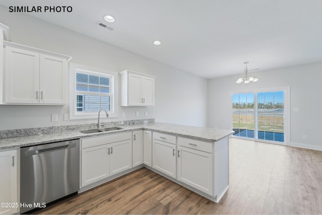 kitchen with visible vents, dishwasher, a peninsula, white cabinetry, and a sink