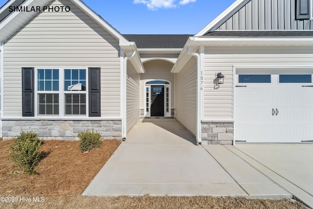 property entrance featuring stone siding, roof with shingles, board and batten siding, and an attached garage