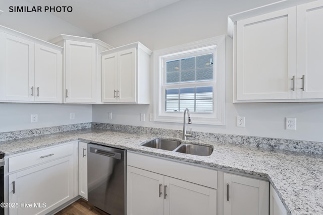 kitchen with light stone counters, a sink, white cabinets, and stainless steel dishwasher