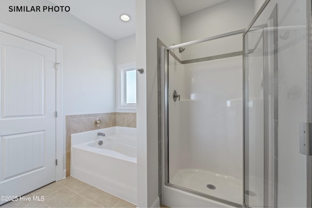 full bath featuring tile patterned flooring, a shower stall, and a garden tub