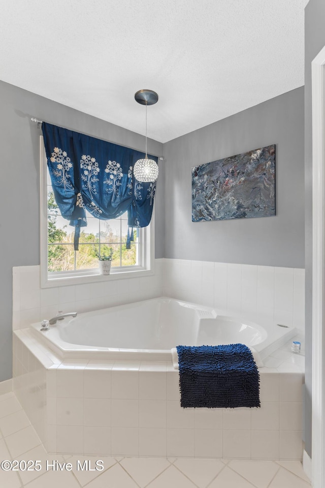 full bath featuring a garden tub and a textured ceiling