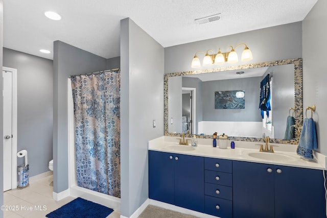 bathroom featuring double vanity, toilet, visible vents, and a sink