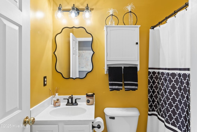 bathroom featuring curtained shower, toilet, and vanity