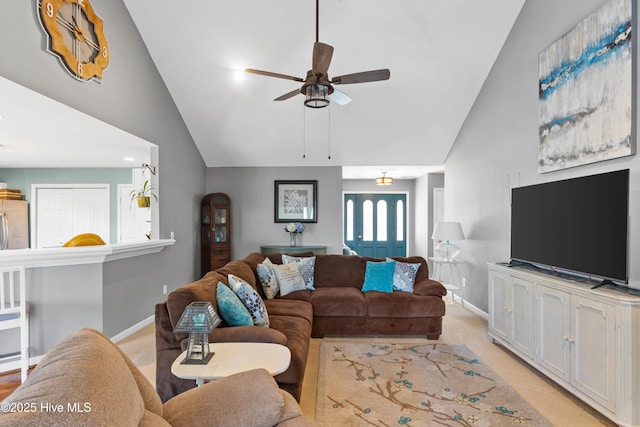 living room featuring light carpet, baseboards, ceiling fan, and vaulted ceiling