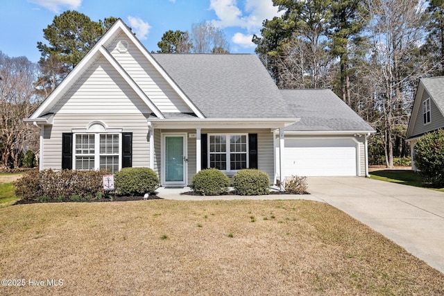 traditional-style house featuring a garage, concrete driveway, a front lawn, and a shingled roof