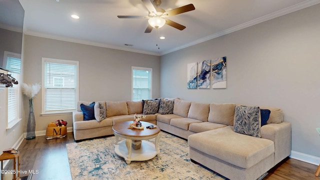 living area featuring baseboards, wood finished floors, visible vents, and crown molding