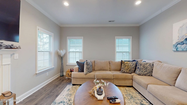 living area with ornamental molding, visible vents, baseboards, and wood finished floors