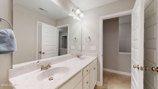 full bath with visible vents, a sink, baseboards, and double vanity