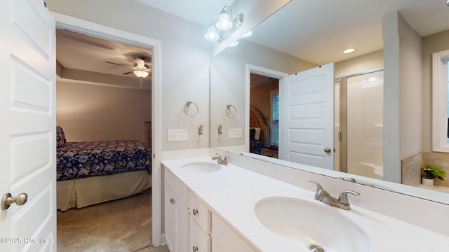 bathroom with a shower with shower door, connected bathroom, a sink, and double vanity