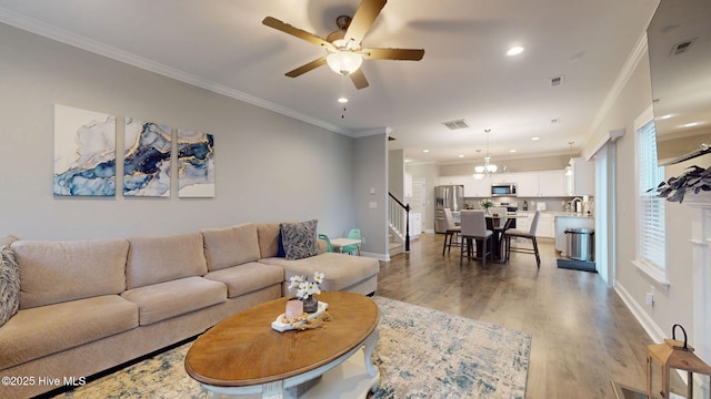 living area with ornamental molding, light wood-style flooring, and visible vents