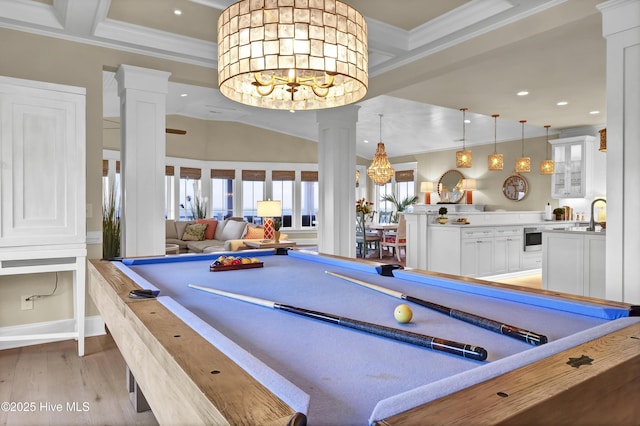 game room with a notable chandelier, billiards, light wood-style floors, ornate columns, and crown molding