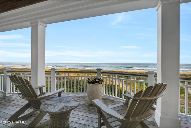 deck featuring a beach view and a water view