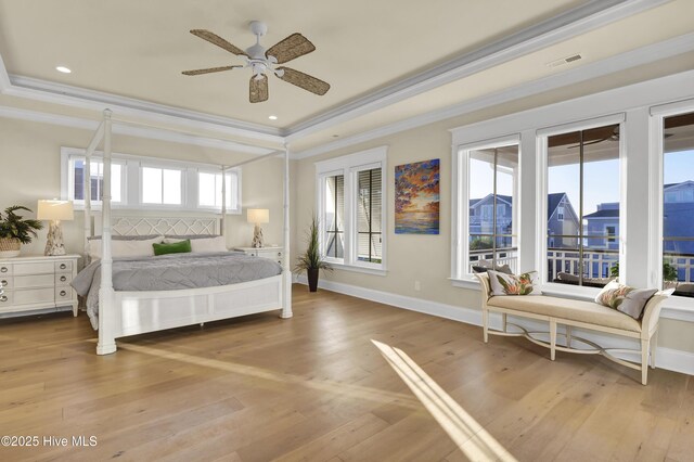 bedroom with baseboards, a tray ceiling, and wood finished floors