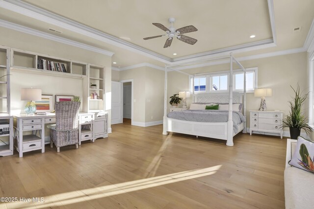 bedroom with a tray ceiling, visible vents, baseboards, and wood finished floors