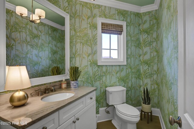 bathroom featuring vanity, toilet, and wallpapered walls