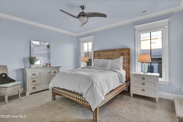 bedroom with ornamental molding, visible vents, light carpet, and multiple windows