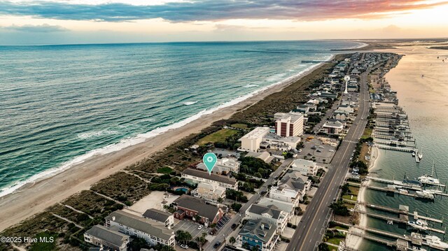 aerial view at dusk with a view of the beach and a water view